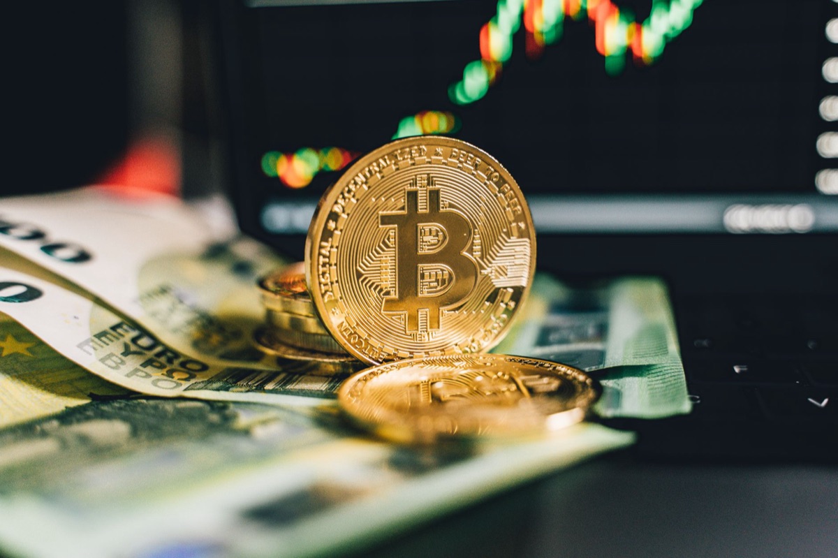 Bitcoin munt met Europese bankbiljetten op een bureau