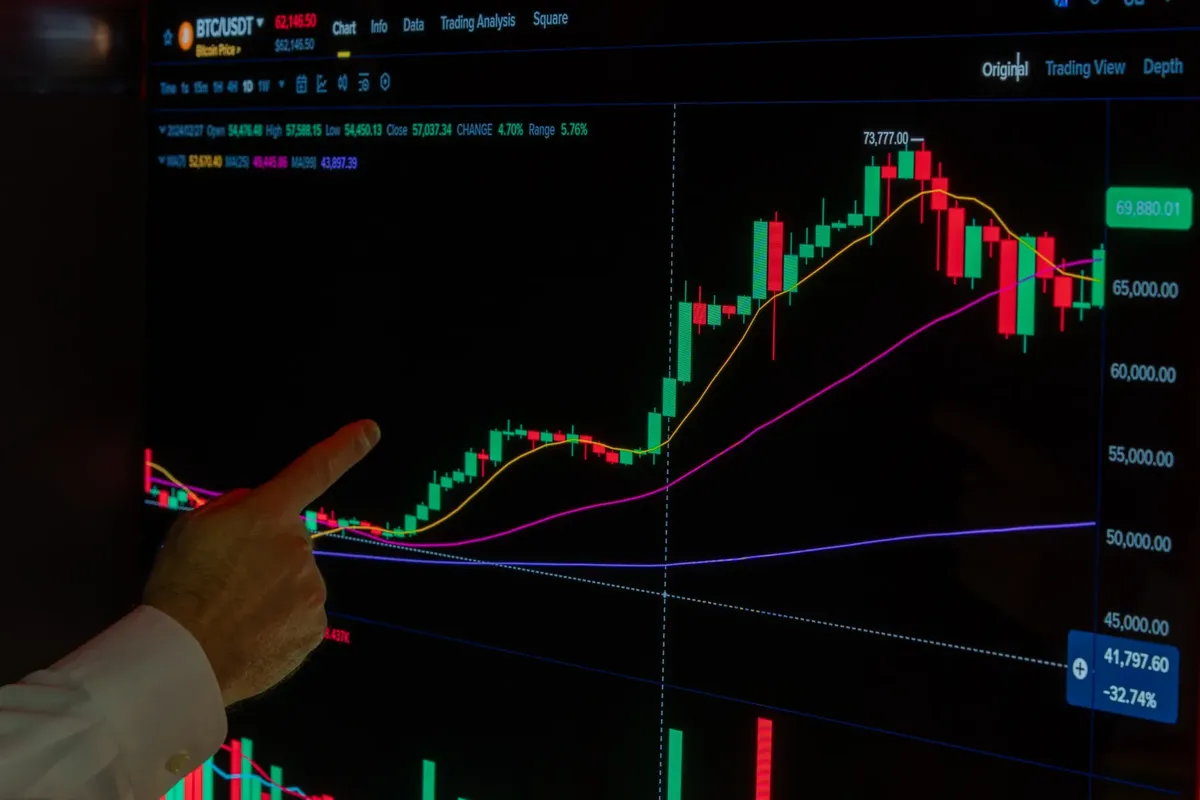 Hand pointing at cryptocurrency chart showing market trends and analysis.