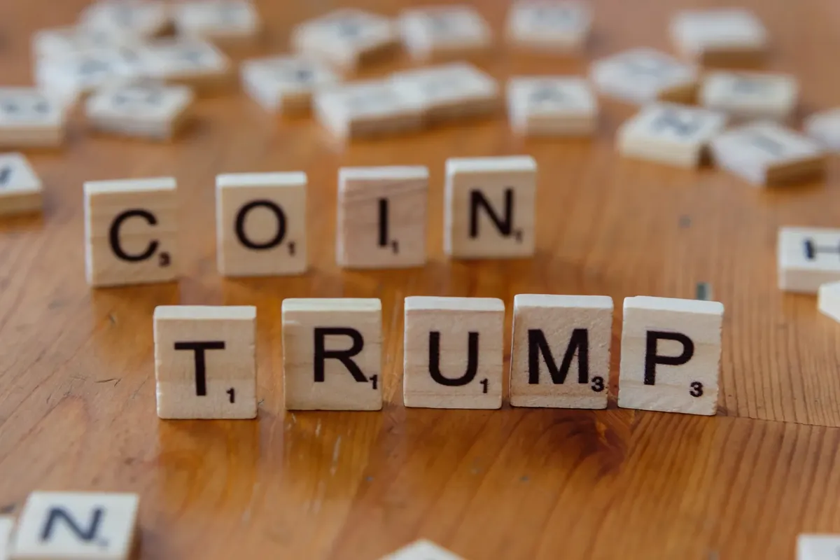 Scrabble tiles spelling 'TRUMP' on a wooden table, creating a political theme.